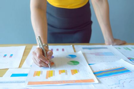 The businesswomen working the plans by hand check the profit graph finances in the office. Concept business and financial in cool tone.の写真素材