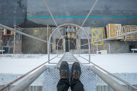 The technician is standing on the top floor of the fire escape staircase.の写真素材