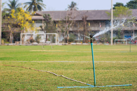 Sprinkler in football field green grassの写真素材