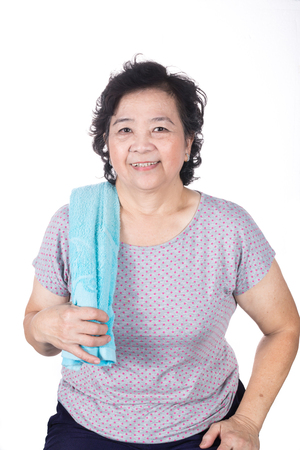 Old Asian woman smiling after workout, holding towel around neck, isolated on white background.の写真素材