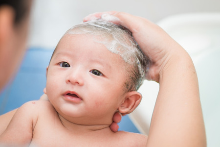 Mother give a bath her newborn baby in bathroom, focus at the eyeの写真素材