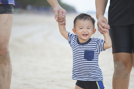 Happy Young Asian Family Having Fun Walking on at tropical beach vacation outdoors, Concept of happy...