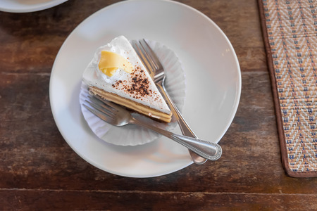 A slice of tiramisu cake on a plate and ready to eat, in coffee shop, Shallow DOF