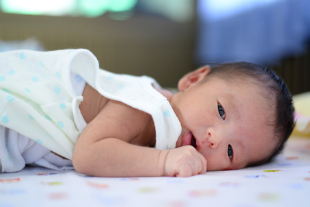 Asian newborn baby on the bed, stay in bed, shallow DOF