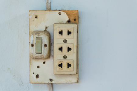Close-up of old socket, electrical outlet, wall socket or outlet plate on the wall