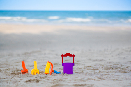 Children's beach toys - buckets, spade and shovel on sand on a sunny day, sea view.の写真素材