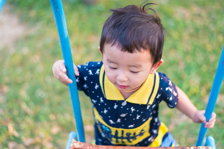Asian kid goes up the stairs in the park. concept of growing up. step by step the child rises higher and goes further.の写真素材