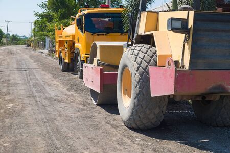 Road construction vehicle on the rough rural road. countryside.