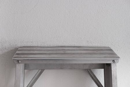 Aluminum ladder on the gray wall, room interior.の写真素材