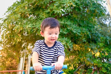 Happy kid play  teeter-totter in kindergarten. warm tone, shallow Focusの写真素材