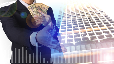 Double exposure businessman holding dollar money and shaking hands, with cityscape and financial graph on blurred building background, business concept
の写真素材