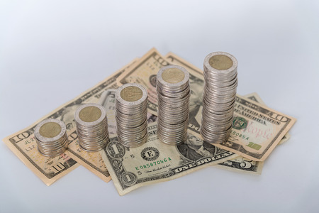 Savings, increasing columns of coins, piles of coins arranged as a graph and American dollar...