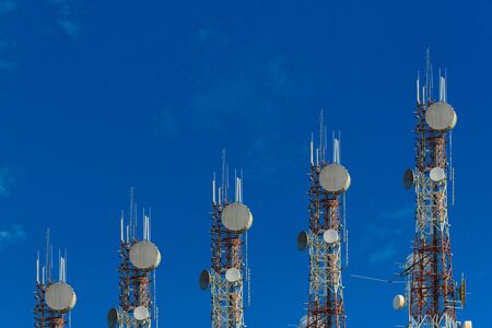 Telecommunication towers arranged as a bar chart. on clear blue sky and cloud background. communication growth concept.の写真素材