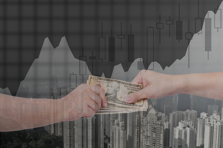 Double exposure of businessman hands exchanging money on city background with financial graph chart, business concept.の写真素材