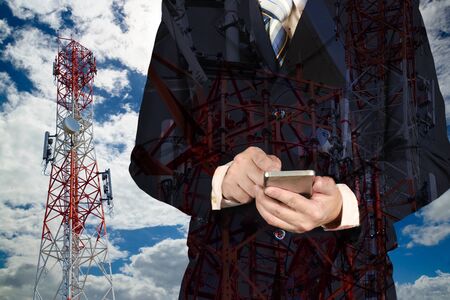 Businessman working digital tablet, with double exposure blue sky and telecommunication towers....