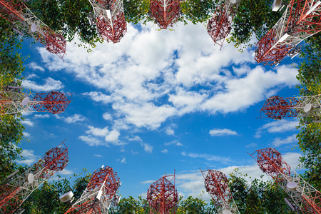 Mobile phone communication antenna tower and tree with cloud blue sky, Telecommunication tower perspective.の写真素材