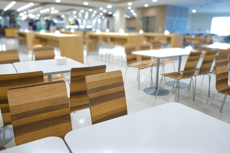 Interior of white table and wooden table on food court in shopping mall. food center in department store. shallow focusの写真素材