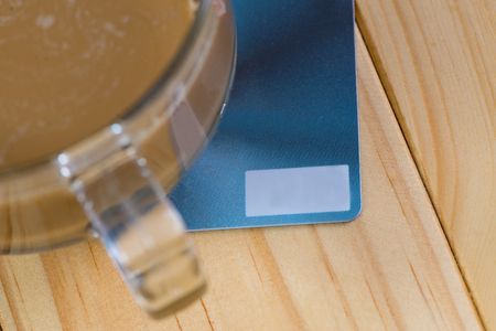 Credit card and glass of hot coffee on wooden table in the morning, soft tone. shallow focusの写真素材