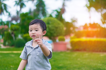 Little Asian kid at the playground under the sunlight in summer, shallow DOFの写真素材