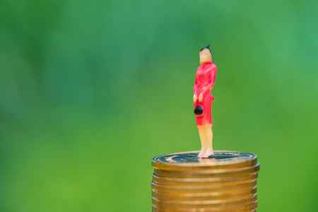 Miniature people, small figures businesswoman on top of coins. Money and Financial, Business Growth concept. shallow focus in soft tone.の写真素材