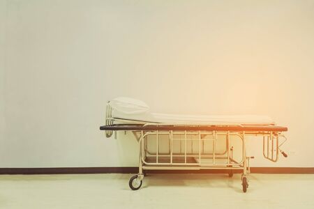 Empty stretcher trolley or hospital trolley waiting for patient with white room. vintage tone with vignetting.の写真素材
