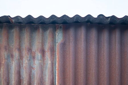 Old rusty corrugated tin zinc metal wall in vintage tone with vignetting.の写真素材