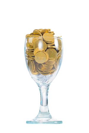 Golden coins in a glass of champagne, isolated on the white background, saving money concept.の写真素材