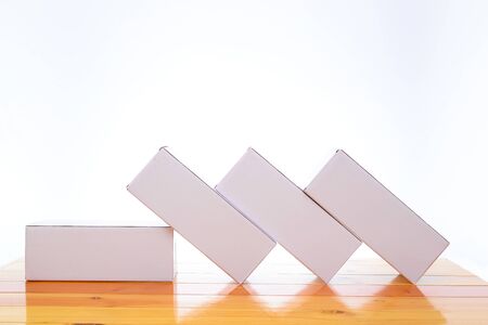 Empty four Package white cardboard box mock up for long items on bright wooden table with copy space.の写真素材