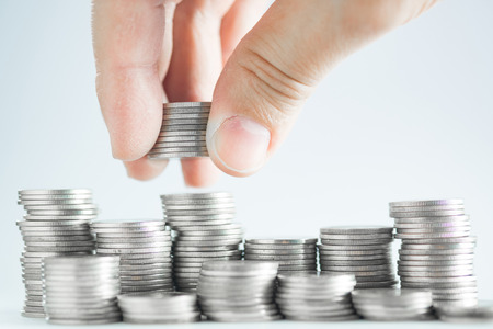Hand put money coins to stack of coins on white background, Money, Financial, Business Growth and...