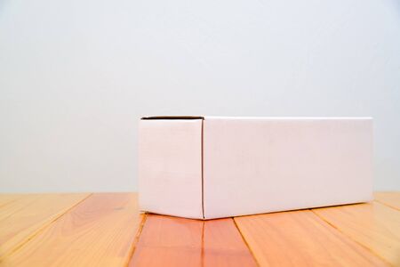 Empty Package white cardboard box mock up for long items on bright wooden table with copy space.の写真素材