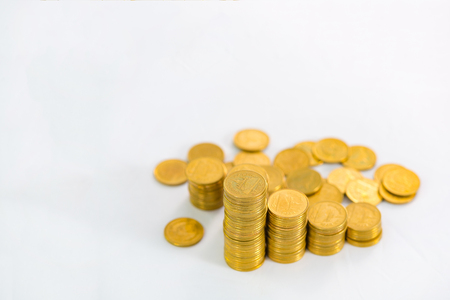 Columns of gold coins, piles of coins arranged on white background, business banking idea, shallow focus.の写真素材