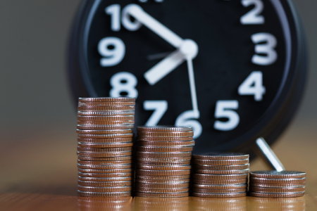 Alarm clock and step of coins stacks on working table, time for savings money concept, banking and...