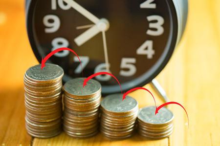 Alarm clock and step of coins stacks on working table with arrow up, time for savings money concept, banking and business idea.の写真素材