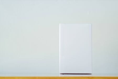 Empty white gift box for mock up on bright wooden table with copy space.