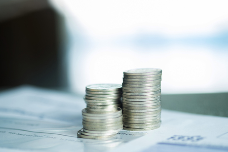 Savings, Piles of coins dollar currency and account book on white background, business idea. shallow focusの写真素材