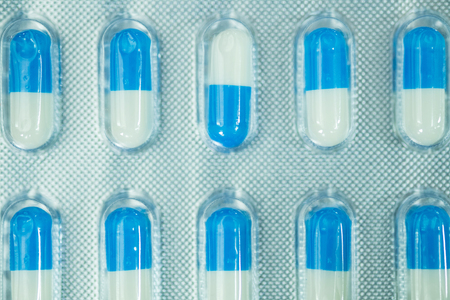 Blue and white tablet in blister on white background. medical and healthy conceptの写真素材