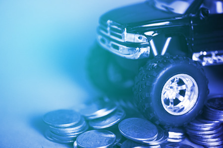 Close up of tire of miniature car pickup truck on stacks of coins with copy space, banking savings money and business finance concept.の写真素材