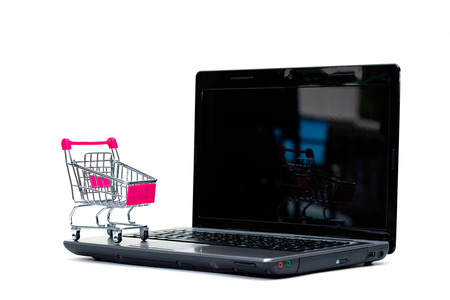 Shopping cart or supermarket trolley with laptop notebook isolated on white background and copy space, e-commerce and online shopping concept.の写真素材