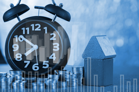 Double exposure of model house and Alarm clock and step of coins stacks with financial graph, time for real estate investment and saving banking money finance concept.の写真素材