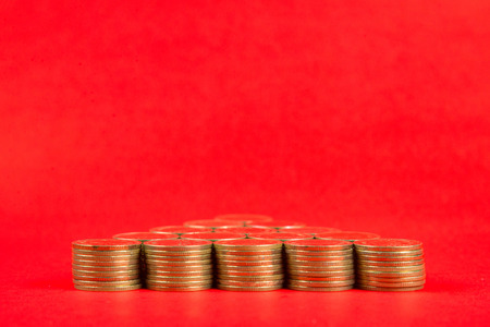 Stacks of coins arranged as a arrow or Christmas tree shape on red background, business metaphor concept idea.の写真素材