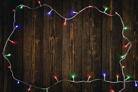 Fancy blinker light bulbs or garlands and wreath on wood table for Christmas or New years decoration...
