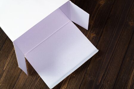Empty white gift box or tray for mock up on dark wooden table with copy space.