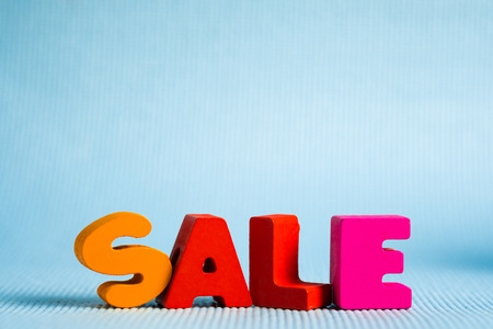 Sale colorful wooden text on blue background with copy space, shopping discount and marketing concept idea. template for add text or photo.の写真素材