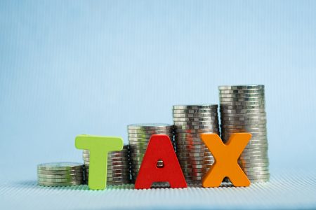 TAX concept. Word TAX alphabet made from wood with stack of coin, business and financial concept idea.の写真素材