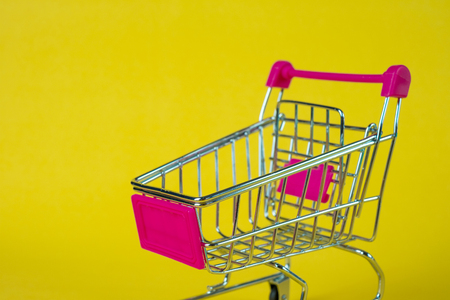 Shopping cart or supermarket trolley on yellow background, business finance shopping concept idea.の写真素材
