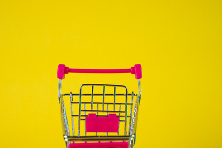 Shopping cart or supermarket trolley on yellow background, business finance shopping concept idea.の写真素材