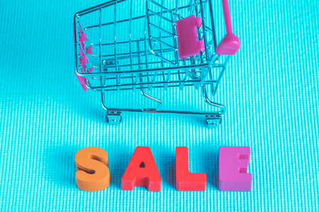 Sale colorful wooden text and shopping cart or supermarket trolley on blue background with copy space, shopping discount and merketing concept idea. template for add text or photo.の写真素材