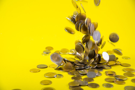 Falling coins money on yellow background, business wealth concept idea.