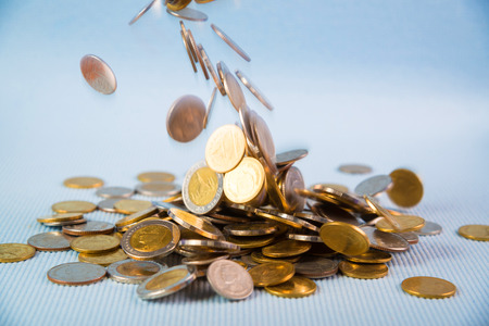 Falling coins money on blue background, business wealth concept idea.