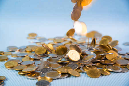Falling coins money on blue background, business wealth concept idea.の写真素材